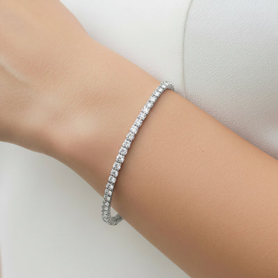 Silver bracelet on a person's wrist with a plain background